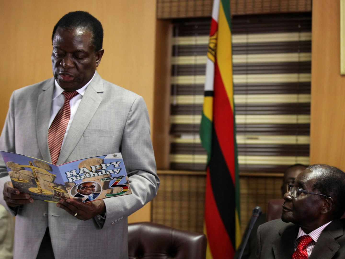 Robert Mugabe observa a Emmerson Mnangagwa mientras lee una felicitación de cumpleaños, en Harare. (Reuters) 