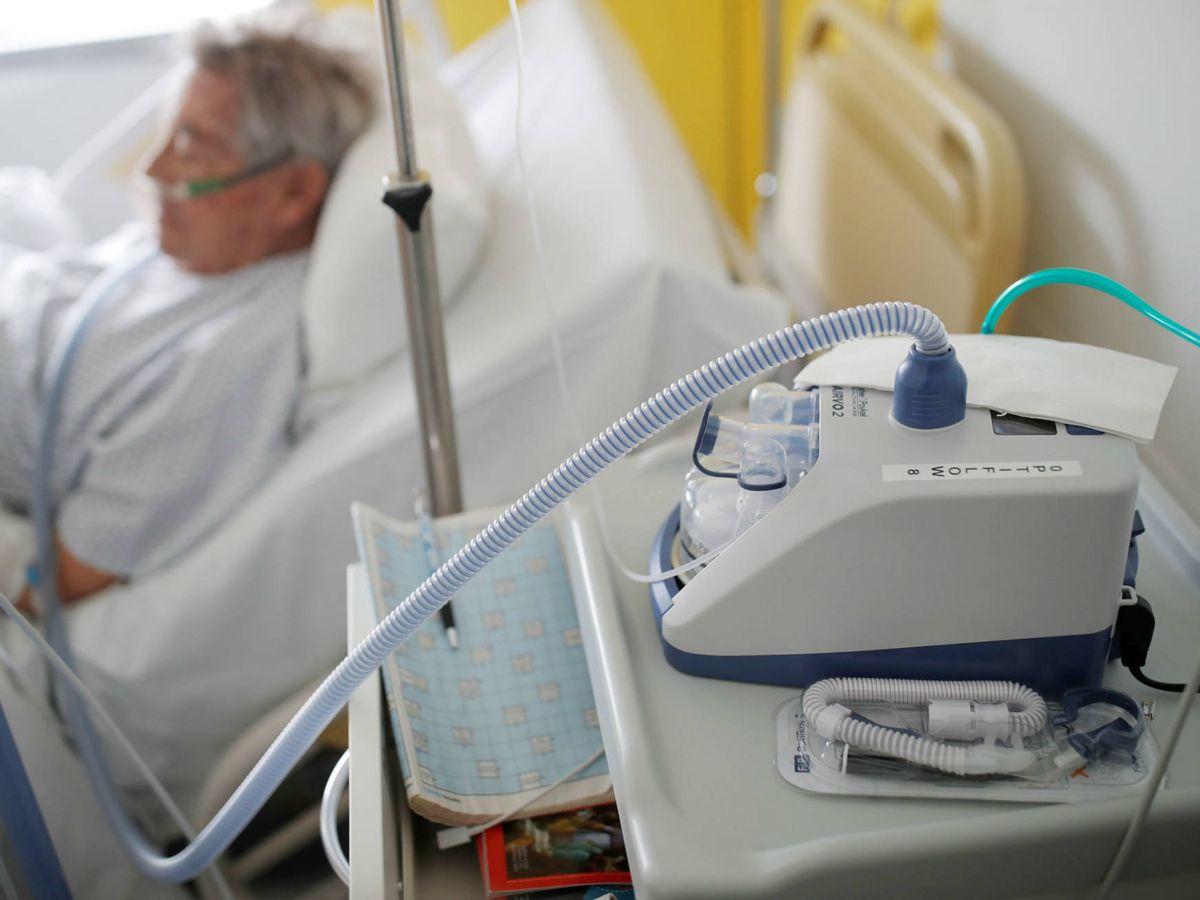 Foto: Un paciente de coronavirus junto a su respirador nasal. (Reuters)