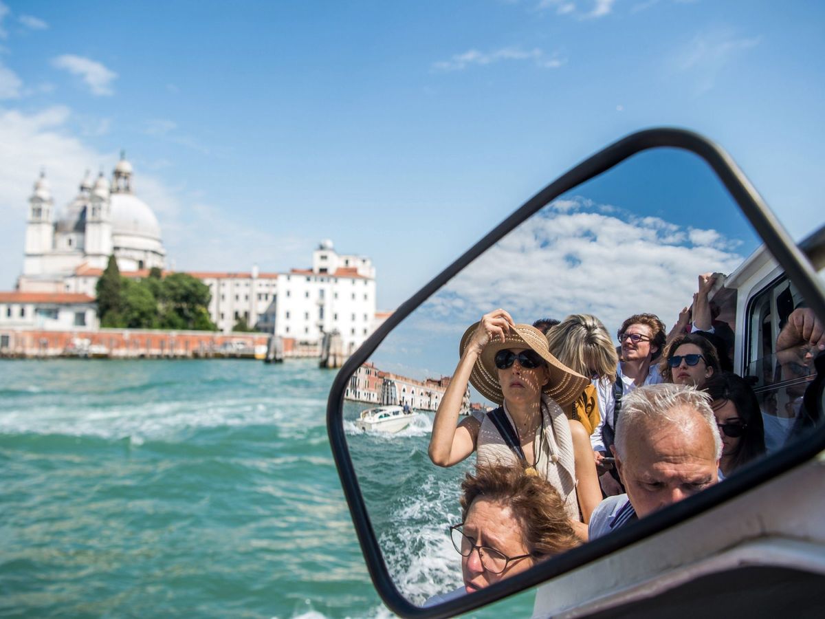 Foto: Turistas viajan en un "vaporetto". (EFE/Zoltan Balogh)