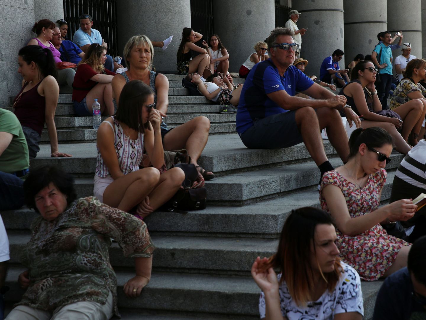 Turistas descansan en las escaleras de la Almudena. (Reuters)