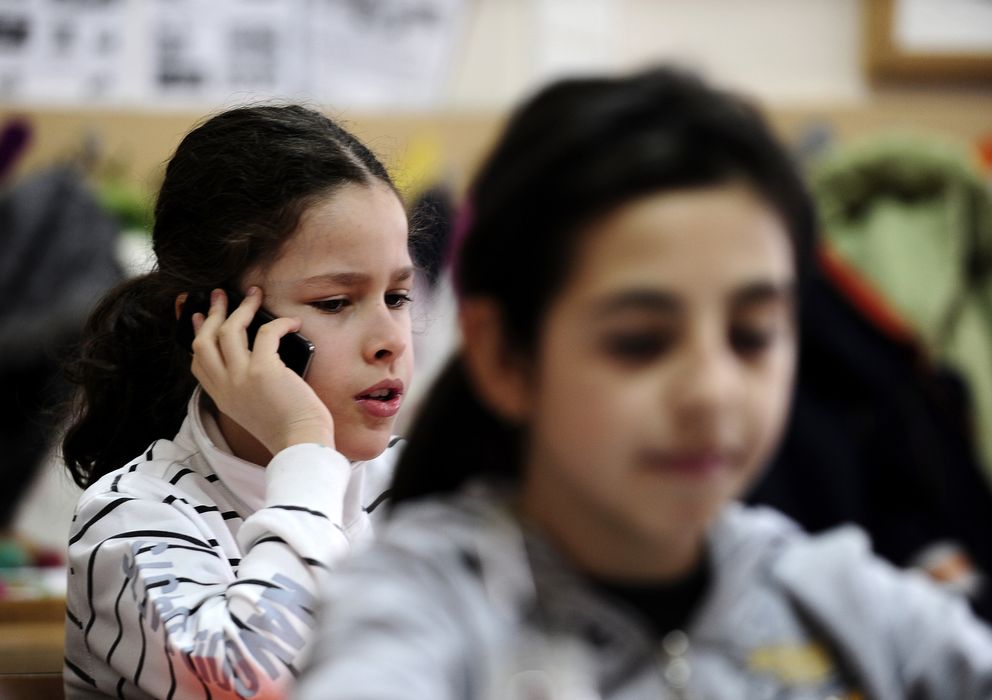 Foto: Dos niñas utilizan su teléfono móvil durante una clase (Reuters)