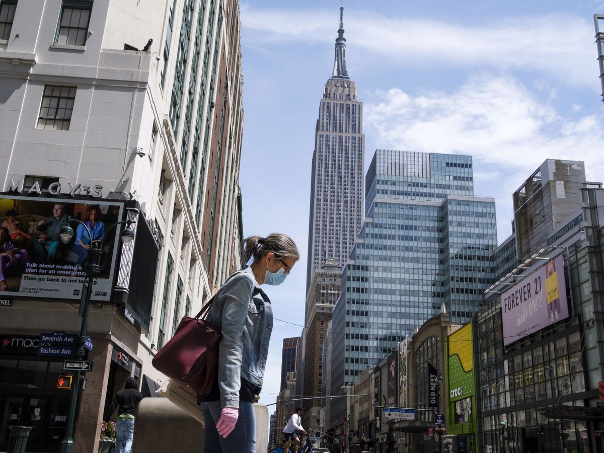 Foto: Una mujer con mascarilla camina por una calle de Nueva York. (EFE)
