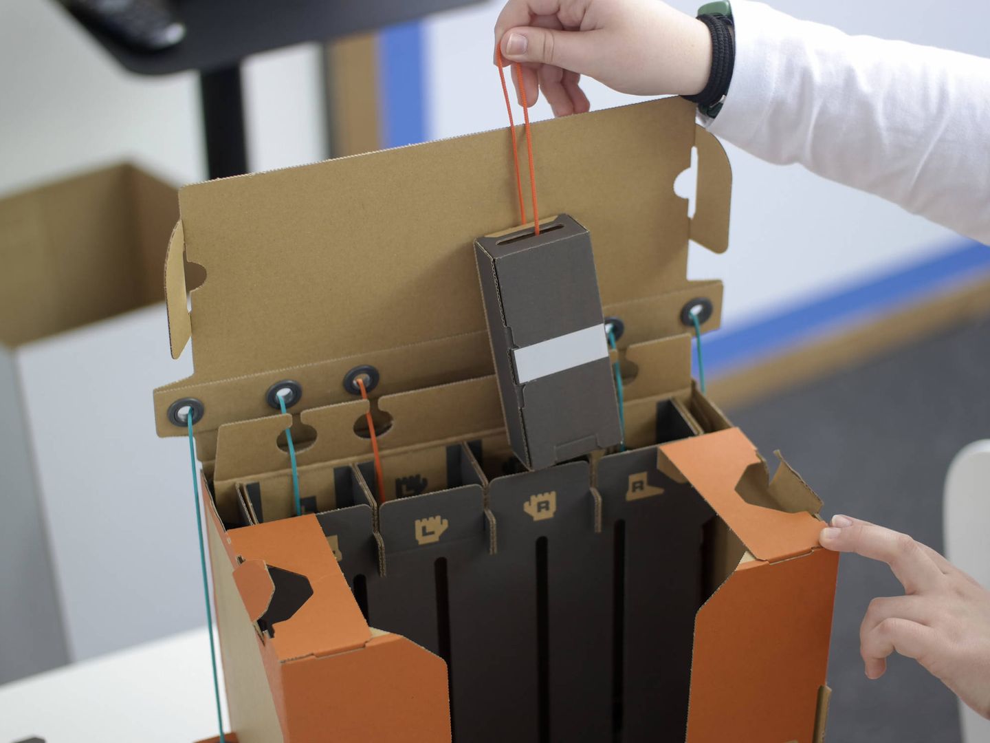 La mochila para manejar el robot de Nintendo Labo funciona con una serie de cajas con pesos y cuerdas. (M.Mcloughlin)