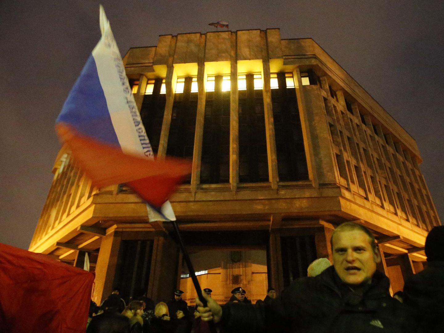 Un hombre ondea una bandera rusa frente al Parlamento de Crimea, en Simferópol (Reuters).