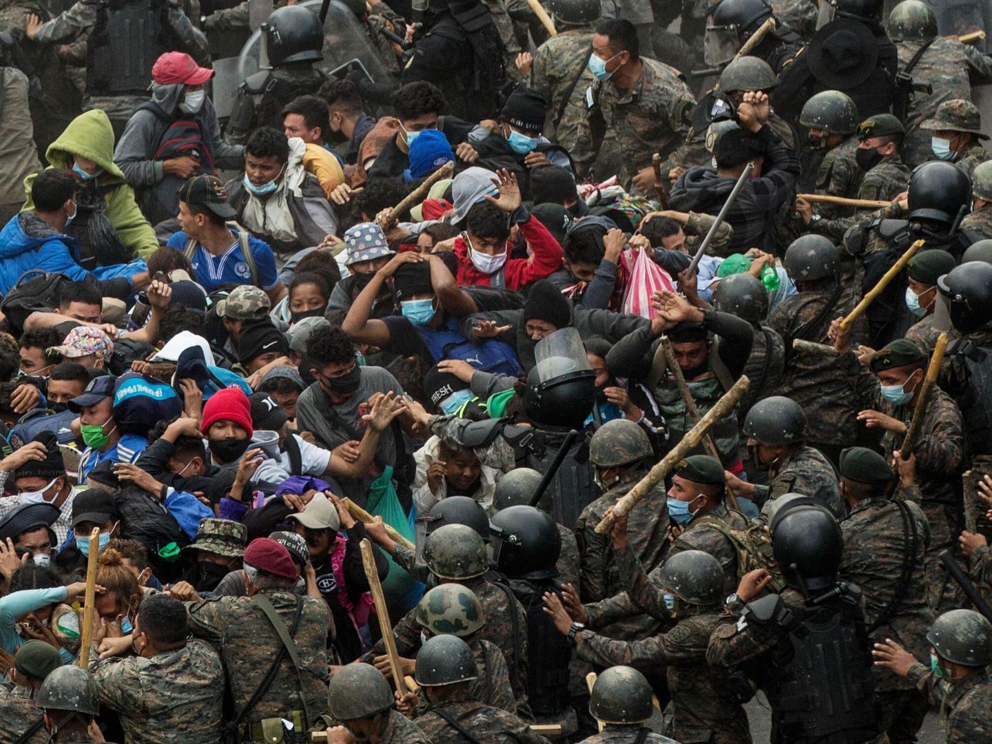 Soldados y policías guatemaltecos golpean a un grupo de migrantes hondureños que caminan por una carretera, en Chiquimula (Guatemala). (EFE)