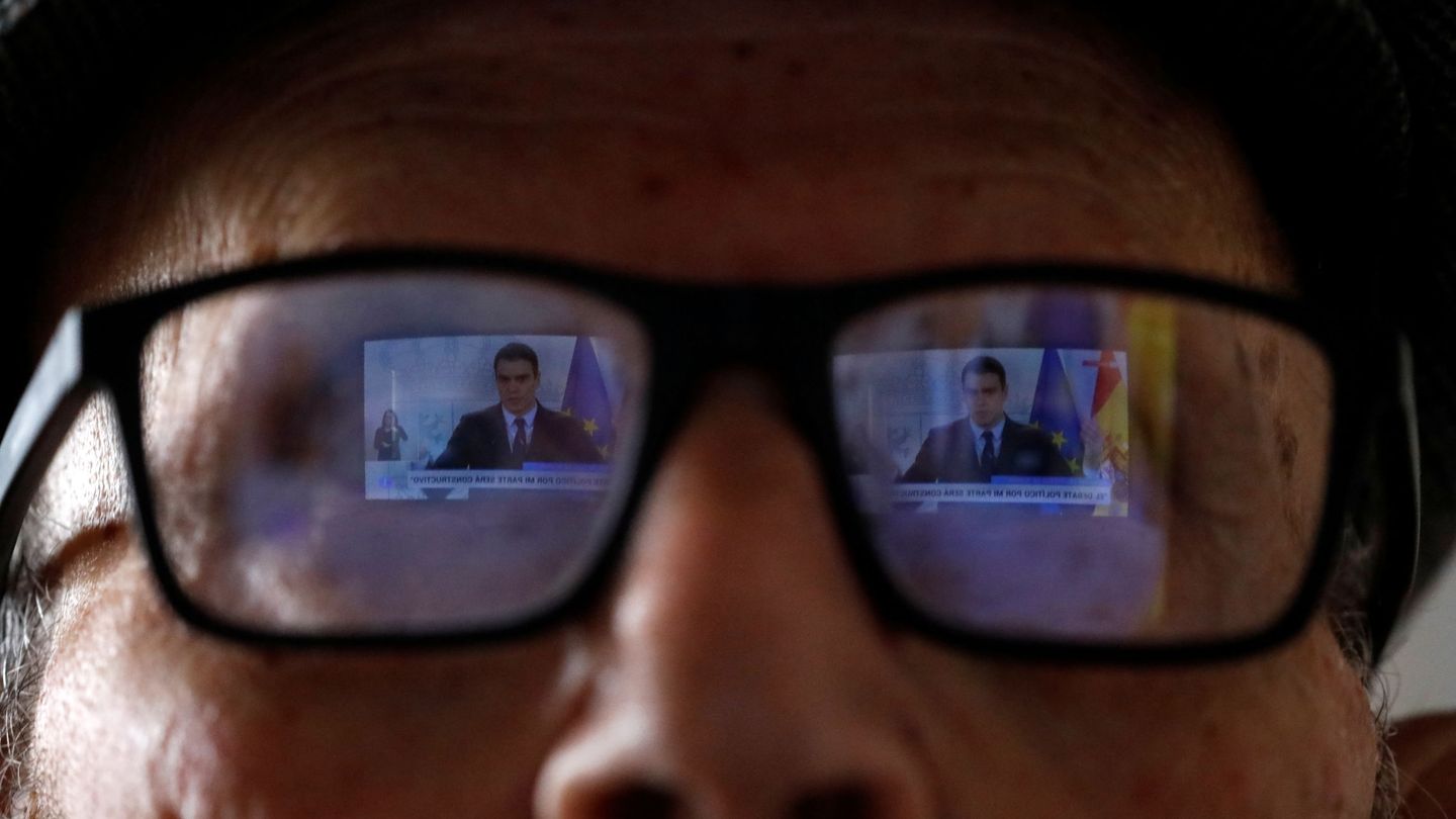 Un hombre ve una intervención de Pedro Sánchez en televisión. (Reuters)