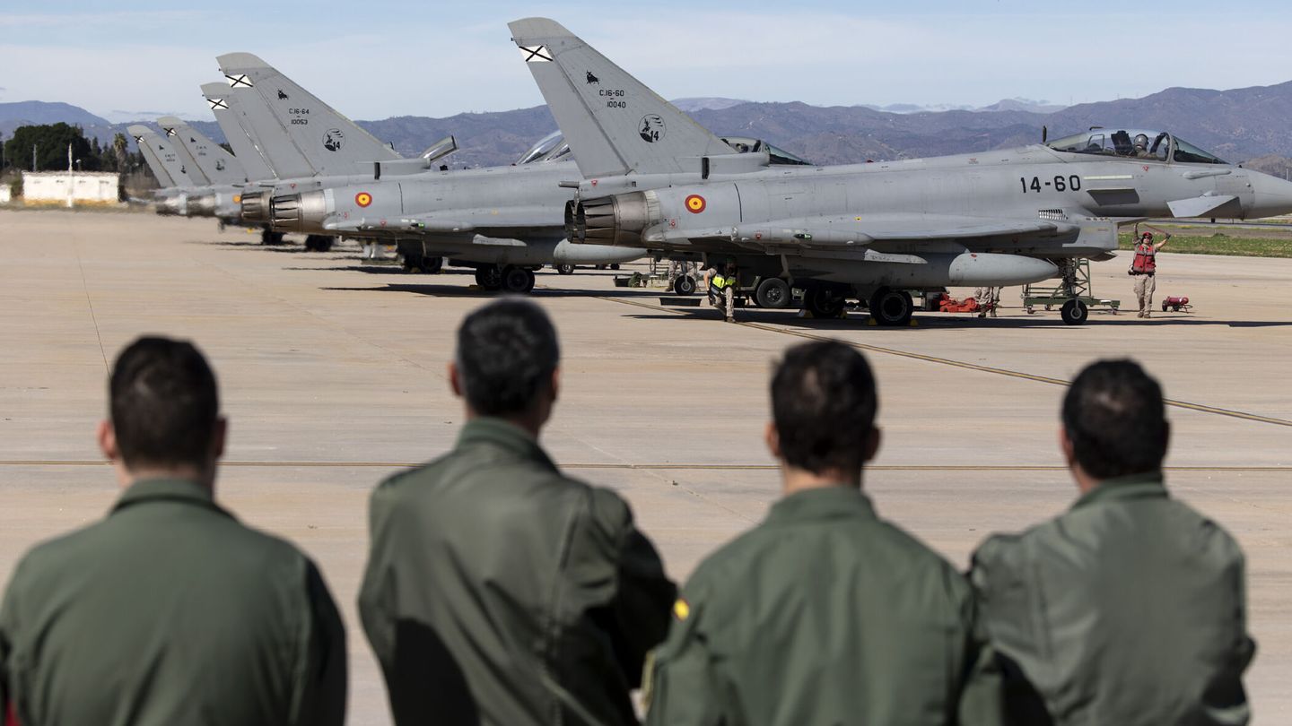 Unos militares observan varios aviones Eurofighter C.16 en la base aérea de Málaga (EFE/Daniel Pérez).