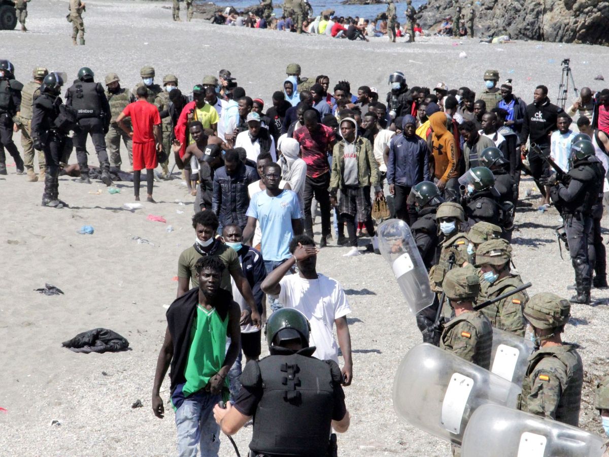 Foto: Soldados vigilan a un grupo de inmigrantes en Ceuta. (EFE)