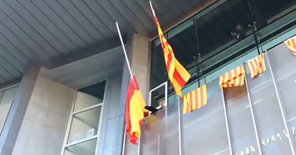 Foto: Miembros de los CDR quitán la bandera de España de la sede de la Generalitat en Girona. (Foto: CDR Girona)