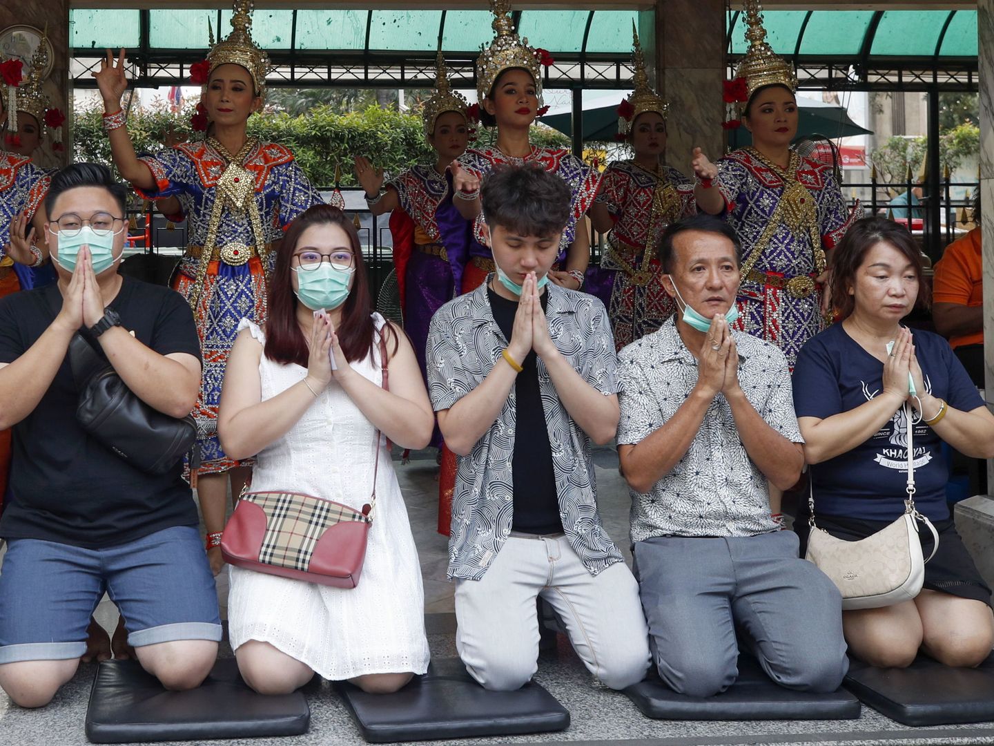 Turistas con mascarillas protectoras rezan en Tailandia (EFE)