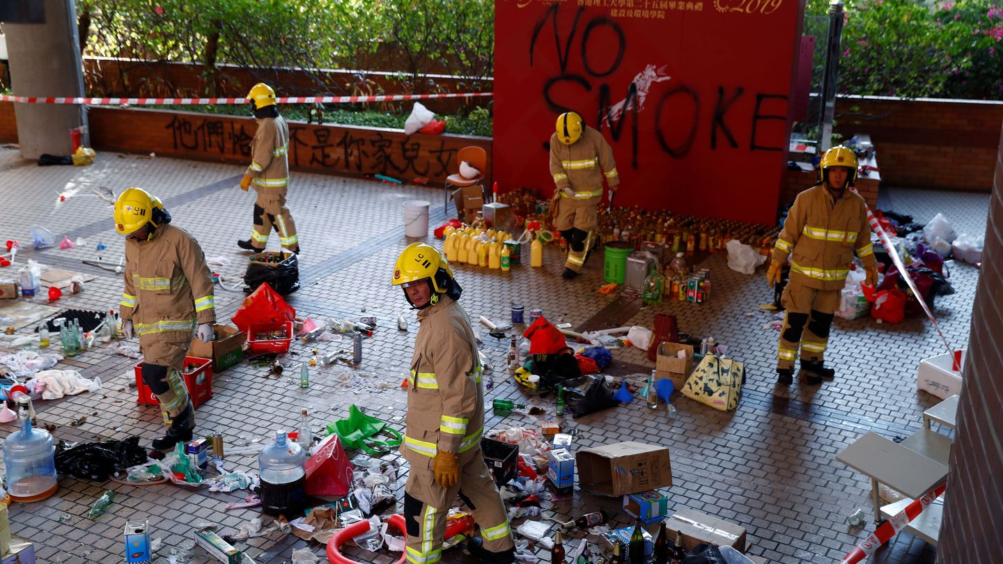 Firefighter examine debris left by protesters the campus of the Polytechnic University (PolyU) in Hong Kong, China, November 28, 2019. REUTERS Thomas Peter