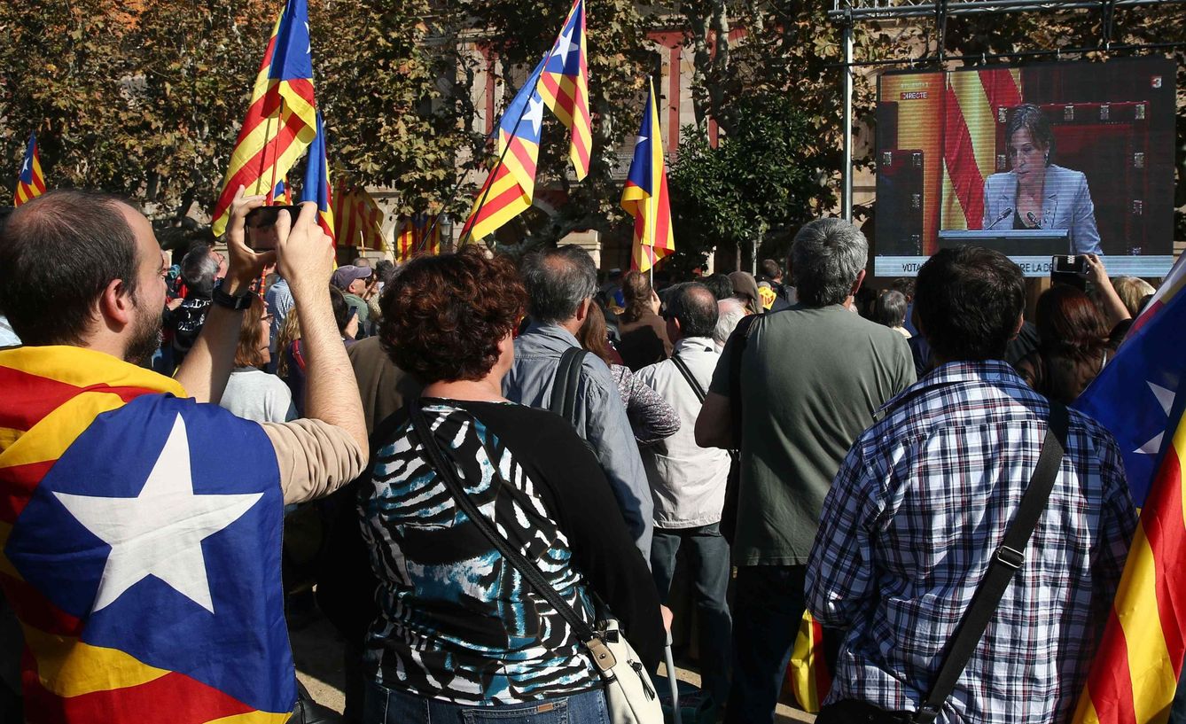 Independentistas catalanes siguen desde una pantalla instalada en el exterior del Parlament el Pleno de la 'Desconexión de España'. (EFE)