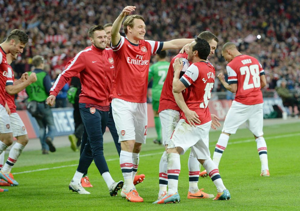 Foto: Los jugadores del Arsenal abrazan a Cazorla, autor del penalti decisivo (EFE).