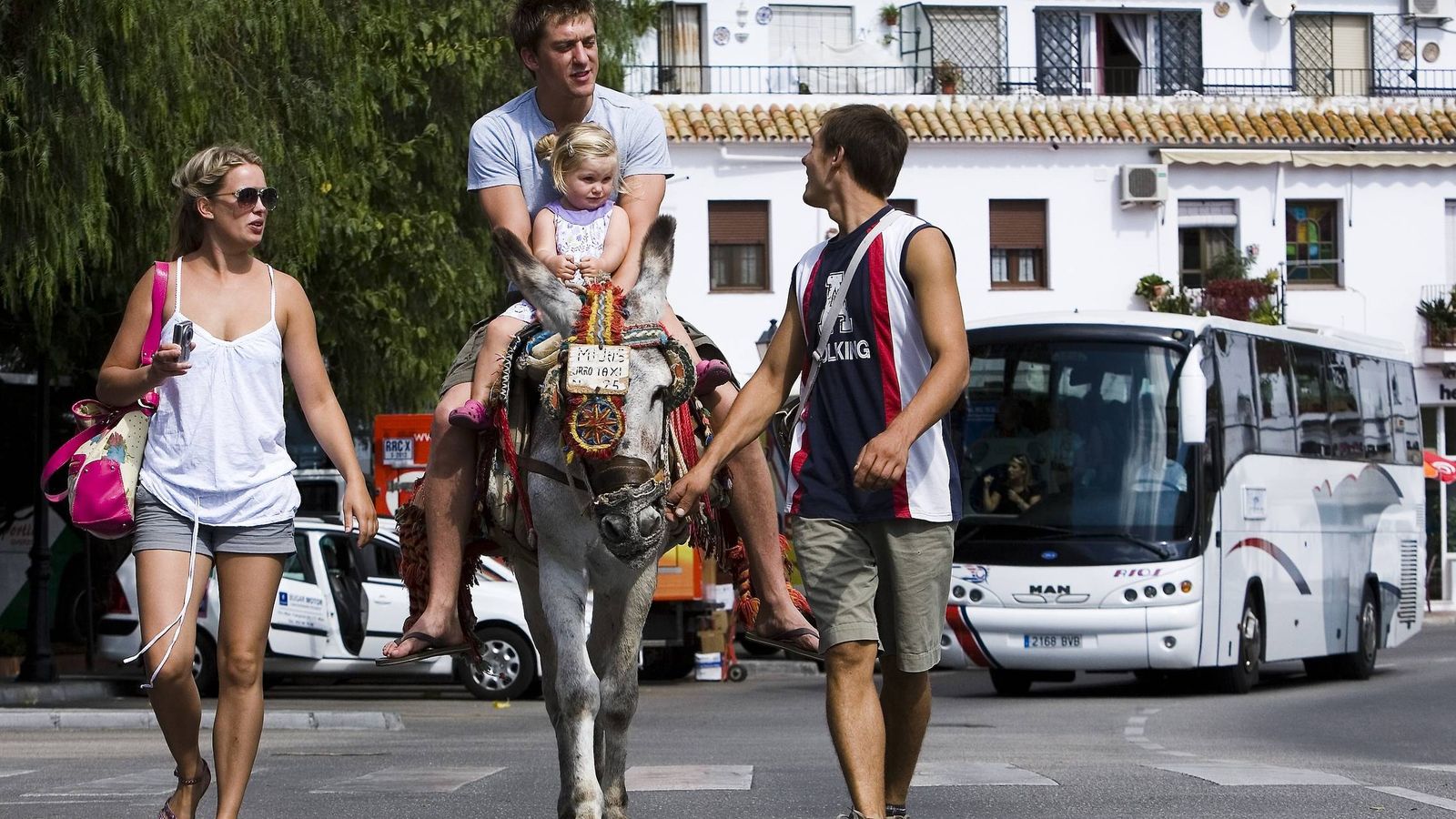 Foto: Unos turistas pasean en un burro-taxi en Mijas. (EFE)