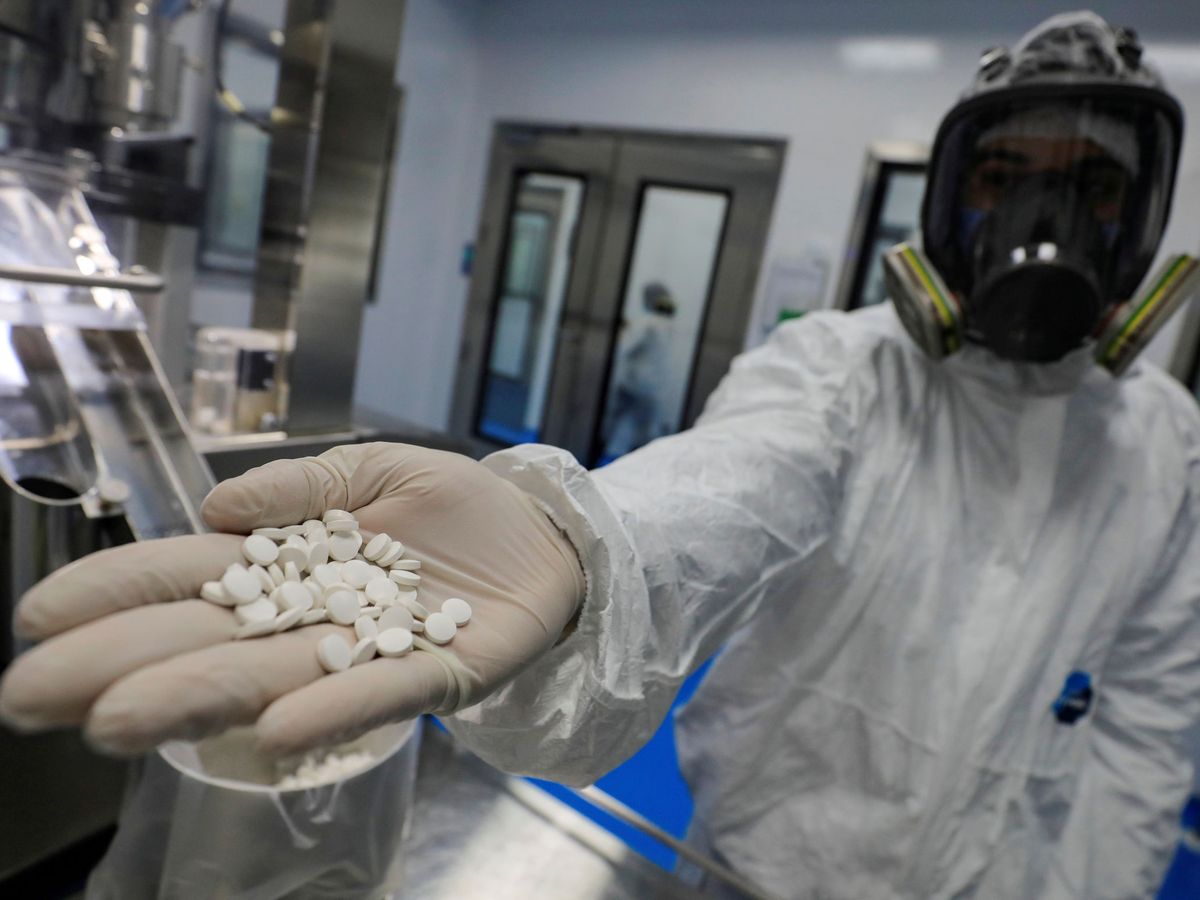 Foto: Un técnico de laboratorio sostiene un puñado de favipiravir en Egipto. (Reuters)