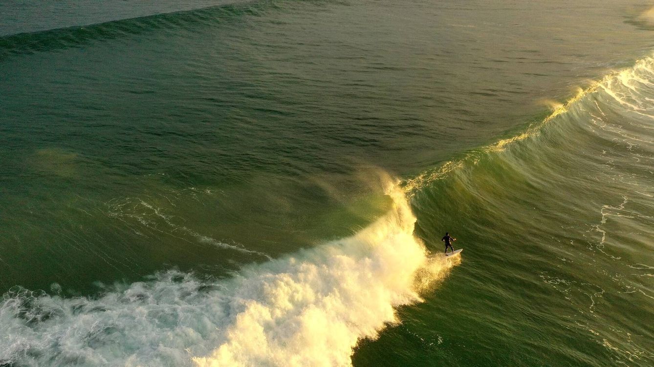 Foto: Surfista sobre una ola verde. (@carlesrgm)