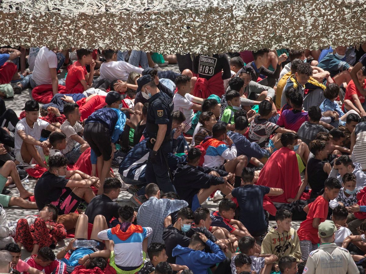Foto: Decenas de migrantes en un polígono industrial de Ceuta. (EFE)