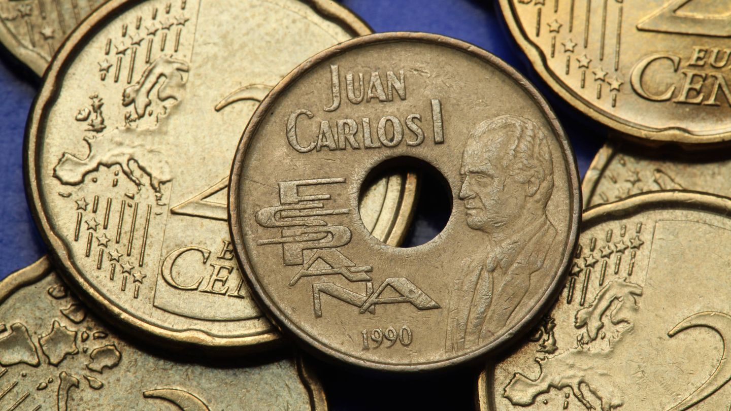 Una moneda de 25 pesetas al lado de otras de 20 de céntimos de euro. (iStock)