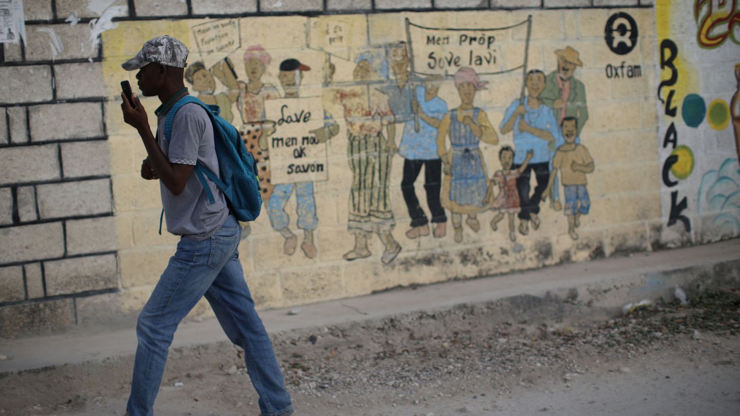 Un joven pasa frente a un cartel de Oxfam en Corail, en las afueras de Puerto Príncipe. (Reuters)