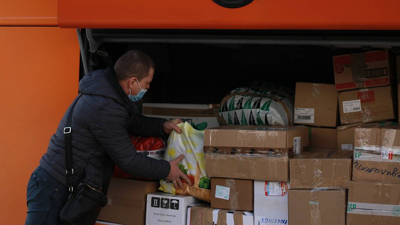 Foto: El conductor del autobús colocando las cajas de ayuda humanitaria en el maletero. (A.F.)