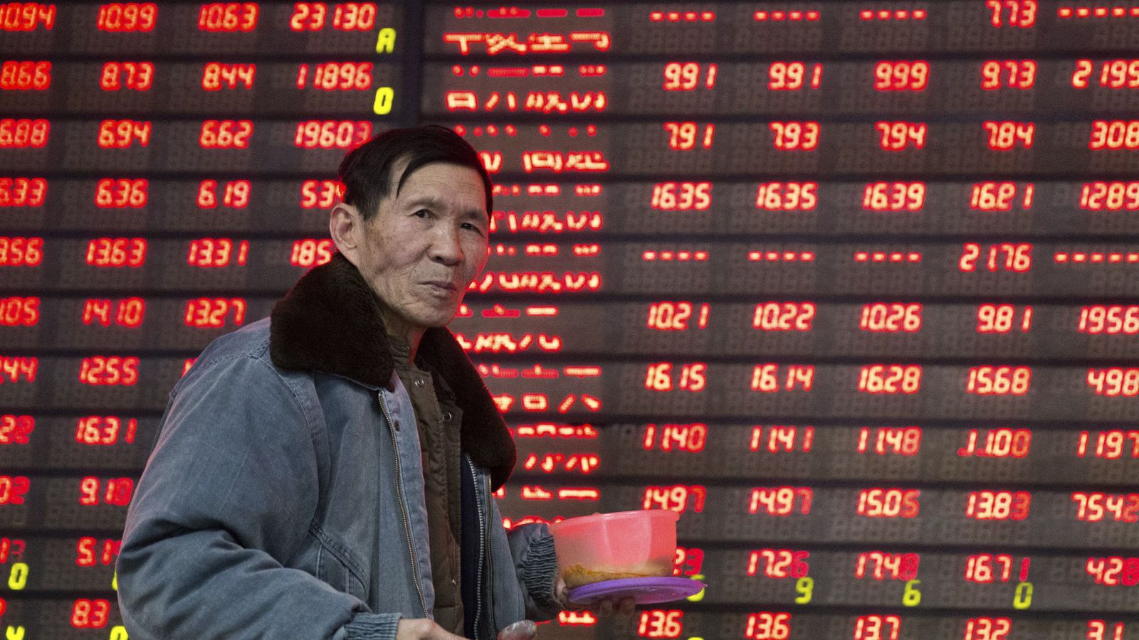 Foto: Un inversor camina delante de un panel informativo de Bolsa. (Reuters)
