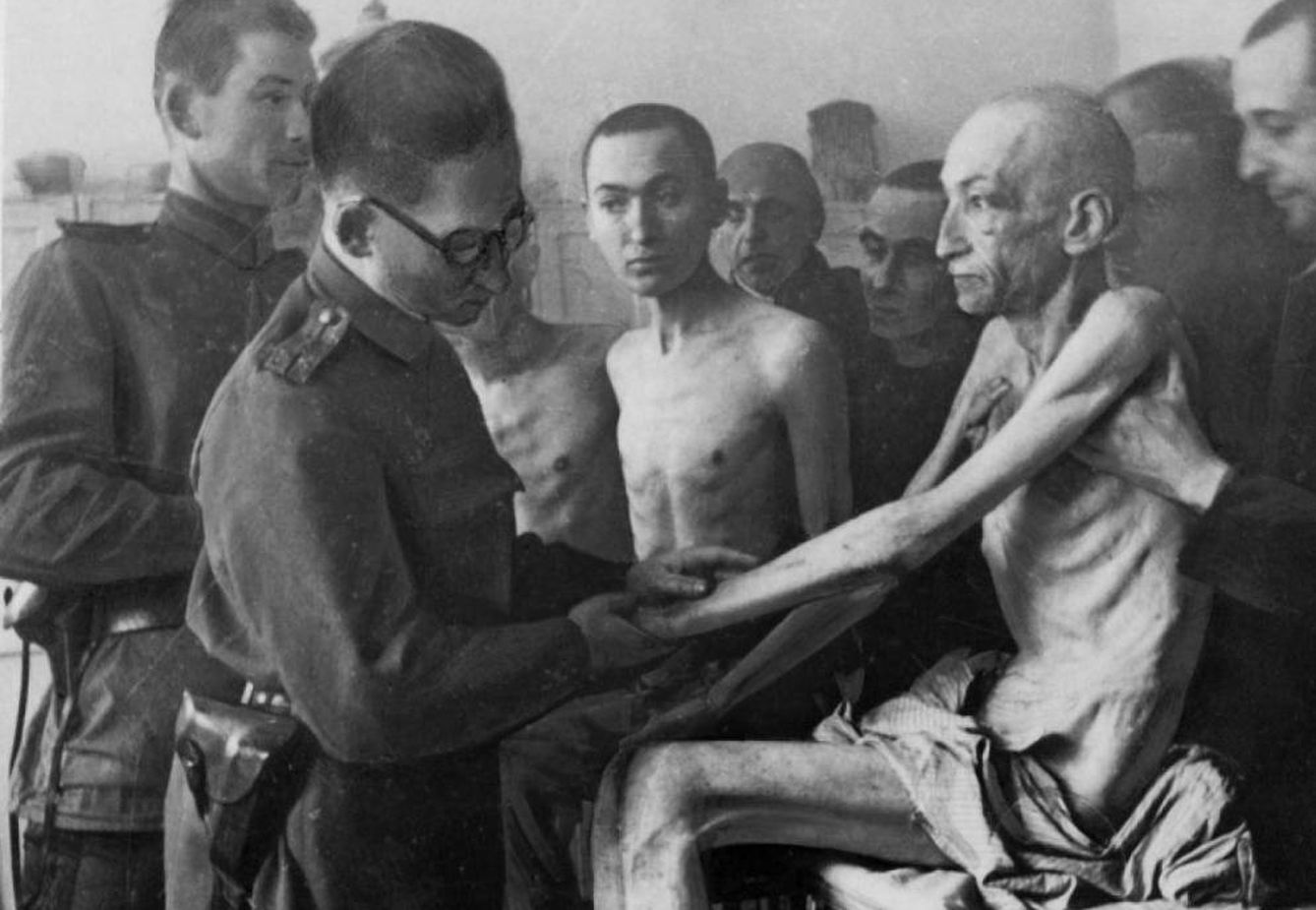 Un militar sanitario de la ‘Armada Roja’ soviética examina a uno de los supervivientes de Auschwitz tras su liberación el 27 de enero de 1945