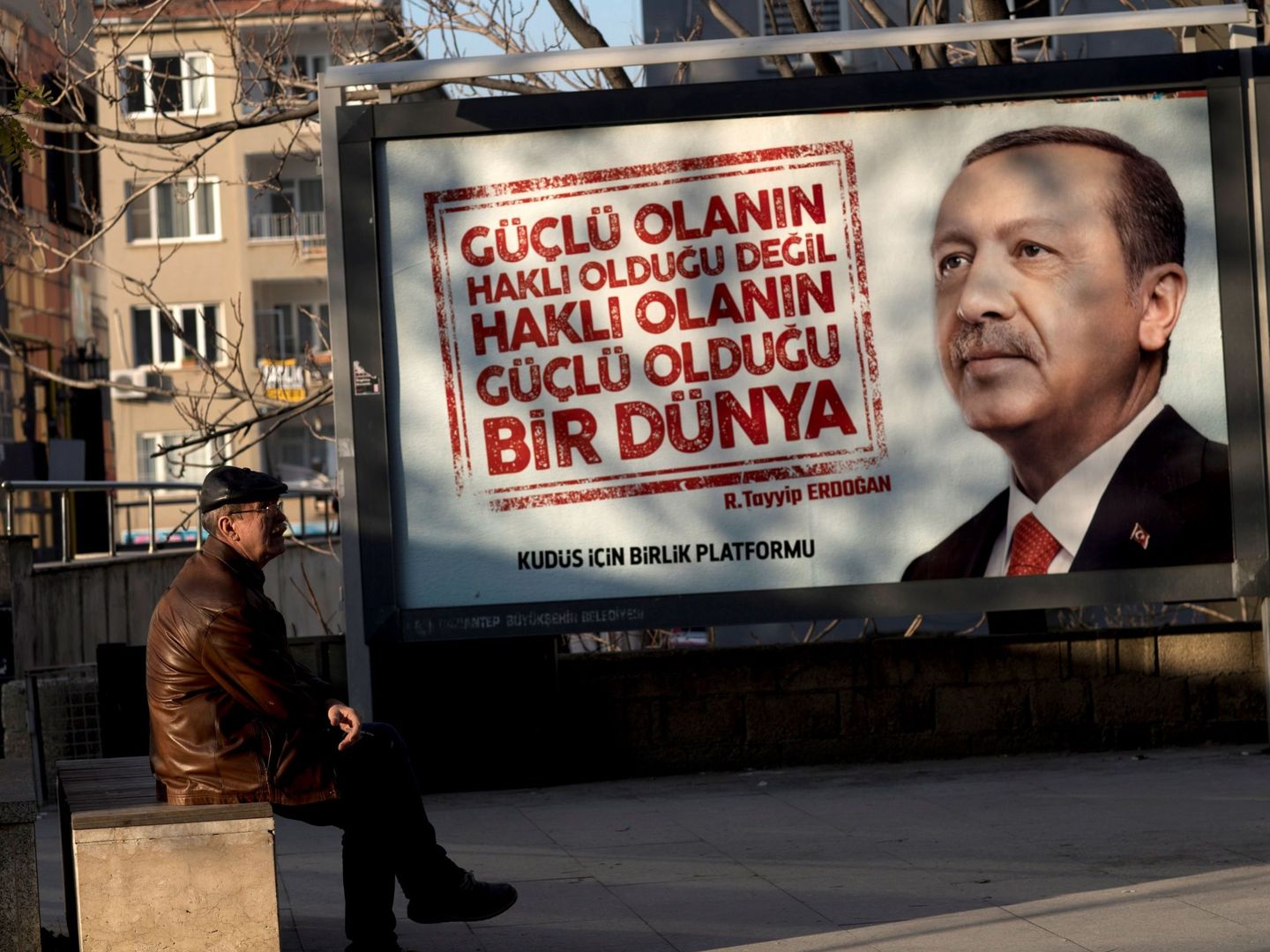 Un hombre se sienta frente a un cartel con la imagen del presidente turco, Recep Tayyip Erdogan, en Gaziantep (Turquía), en diciembre de 2017. (EFE)