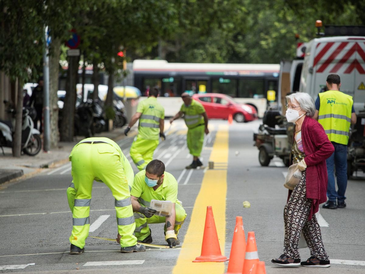 Foto: Operarios del Ayuntamiento de Barcelona trabajan contrarreloj en la ampliación de 12 kilómetros de aceras y de la red de itinerarios ciclables para la desescalada. (EFE)
