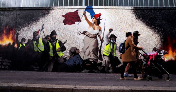 Foto: Personas pasan frente a un mural del artista francés Pascal Boyart sobre los "chalecos amarillos" que versiona la obra de Eugene Delecroix "La libertad guiando al pueblo". (EFE)