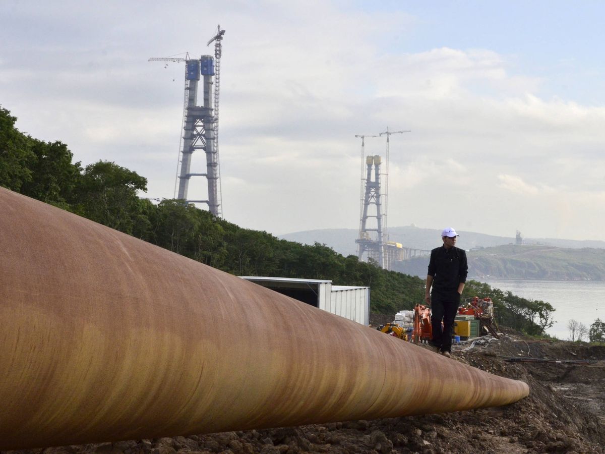 Foto: Un hombre camina sobre un gasoducto en construcción. (Reuters)