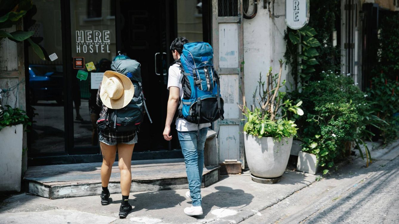 Foto: Dos turistas se dirigen a un hostal. (Pexels)