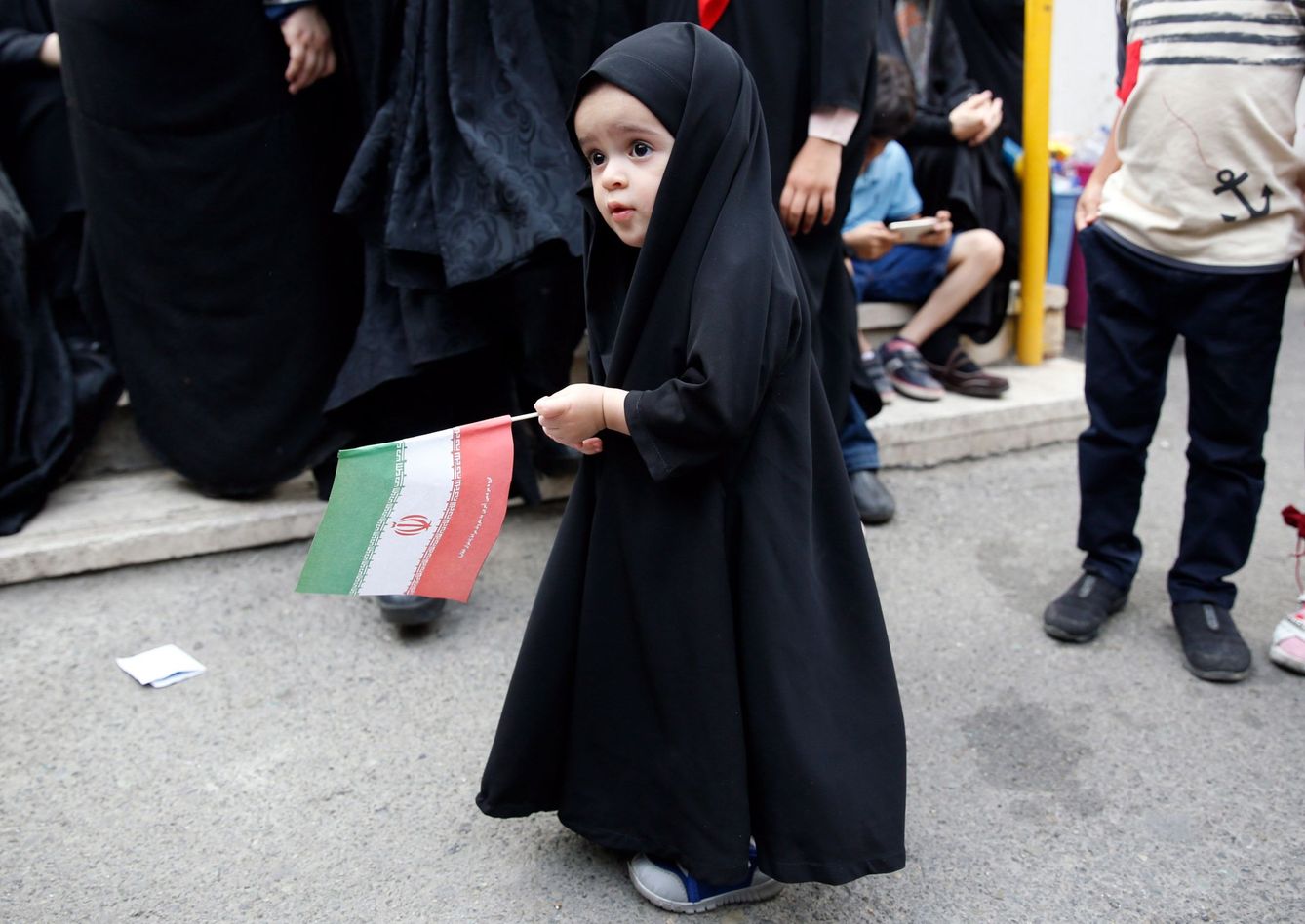 Una niña sostiene la bandera de Irán en una ceremonia de 2019 en apoyo al código de vestimenta obligatorio. (EFE)