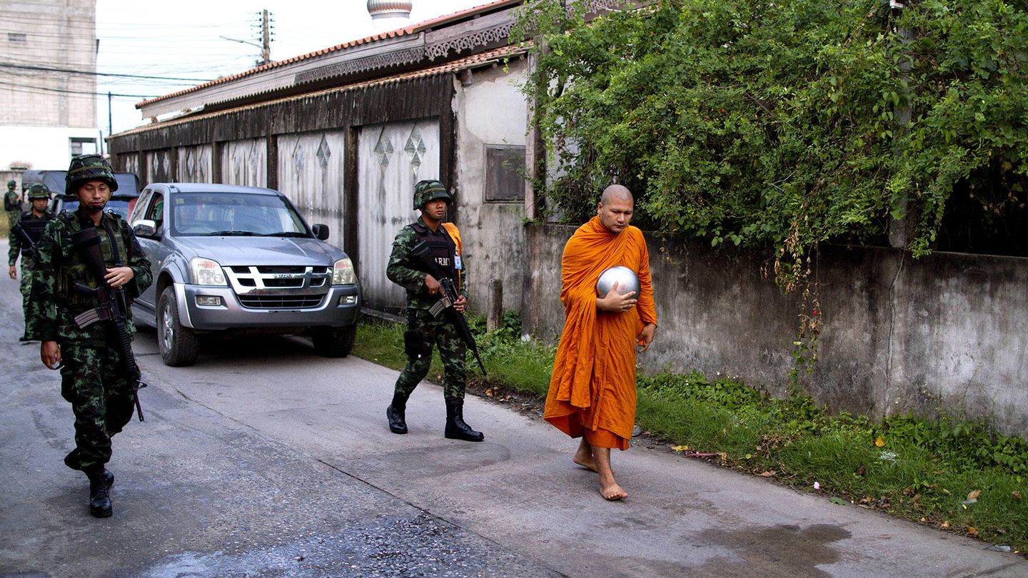 Soldados acompañan a un monje a pedir ofrendas (Biel Calderón)