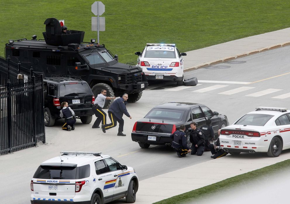 Foto: Agentes de policía se cubren tras sus vehículos después del tiroteo en Ottawa (Reuters).