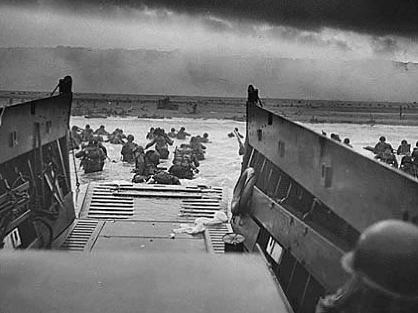 Fotografía facilitada por el ejército de los EEUU que muestra a soldados que esquivan fuego enemigo durante el desembarco de Normandía (Francia).