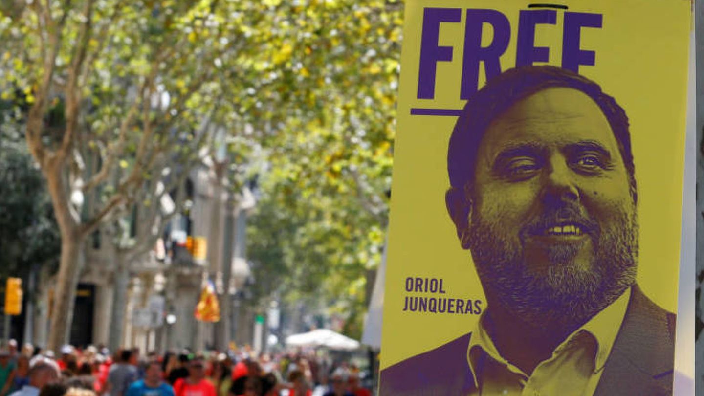 Manifestantes caminan junto a un cartel que pide la libertad de Junqueras. (Reuters)
