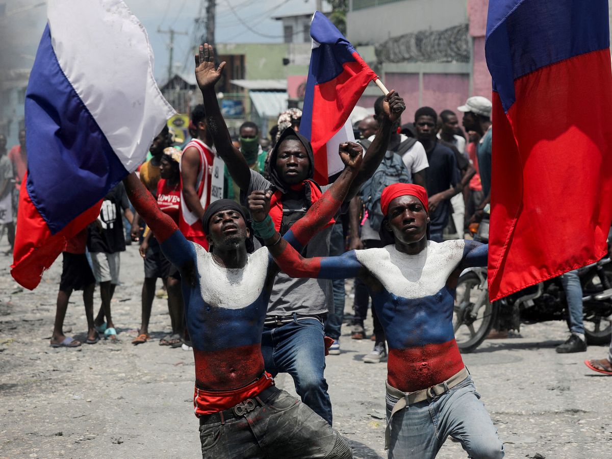 Foto: Manifestantes con banderas rusas y los torsos pintados con los colores de la bandera participan en una protesta en Puerto Príncipe. (Reuters/Ralph Tedy)