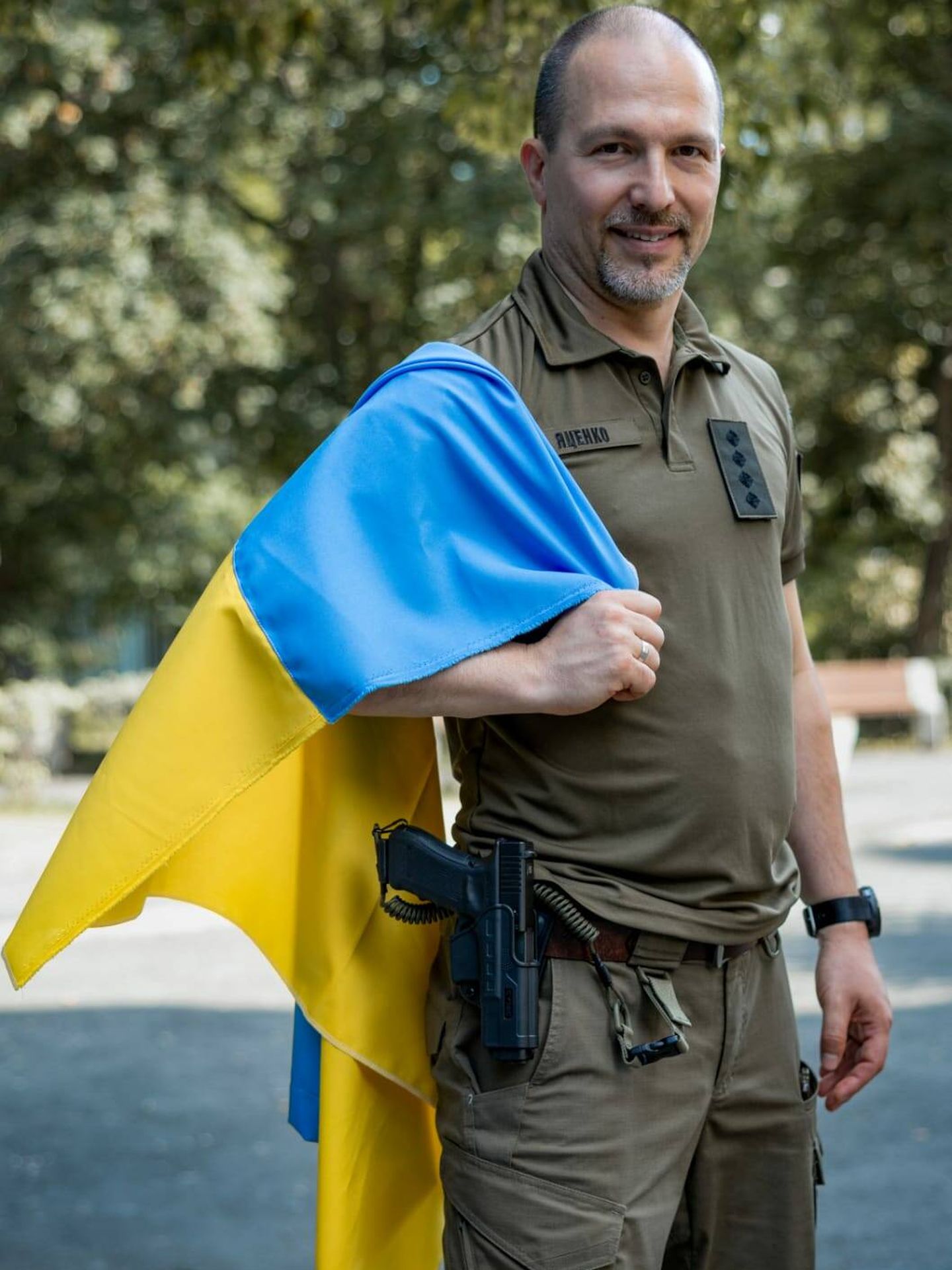 El escritor ucraniano Petro Yatsenko, en su uniforme militar y con una bandera de Ucrania. 