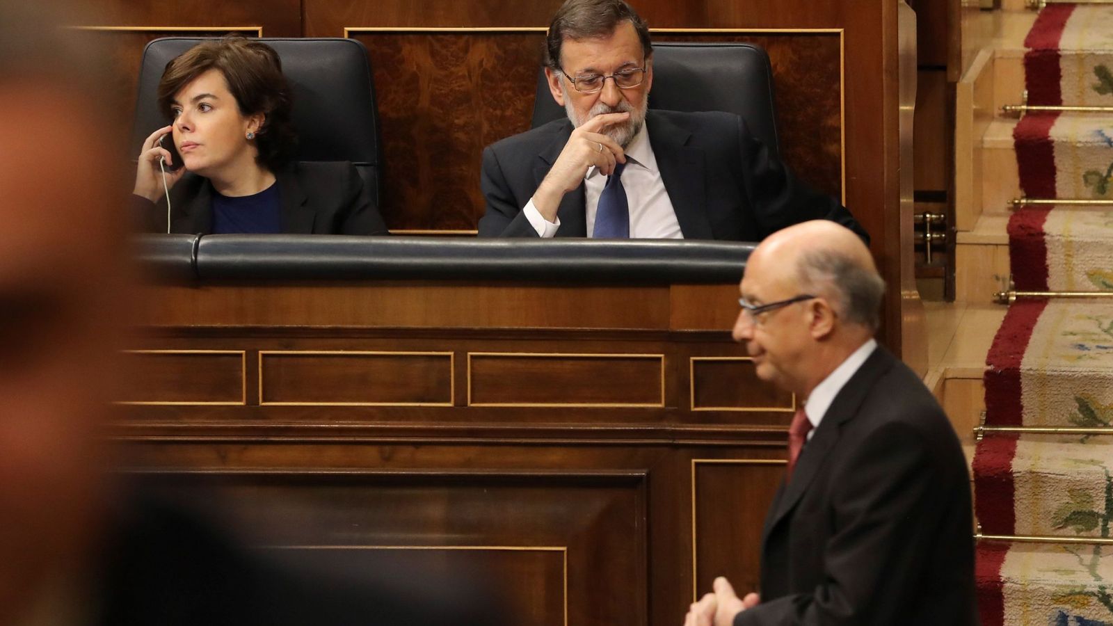 Foto: El ministro de Hacienda y Función Pública, Cristóbal Montoro, pasa junto al presidente del Gobierno, Mariano Rajoy (detrás-d), y la vicepresidenta Soraya Sáenz de Santamaría. (EFE)