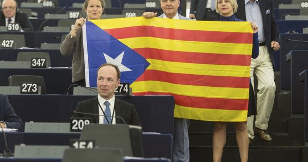 Foto: Eurodiputados posan con una bandera estelada durante el debate. (EFE)