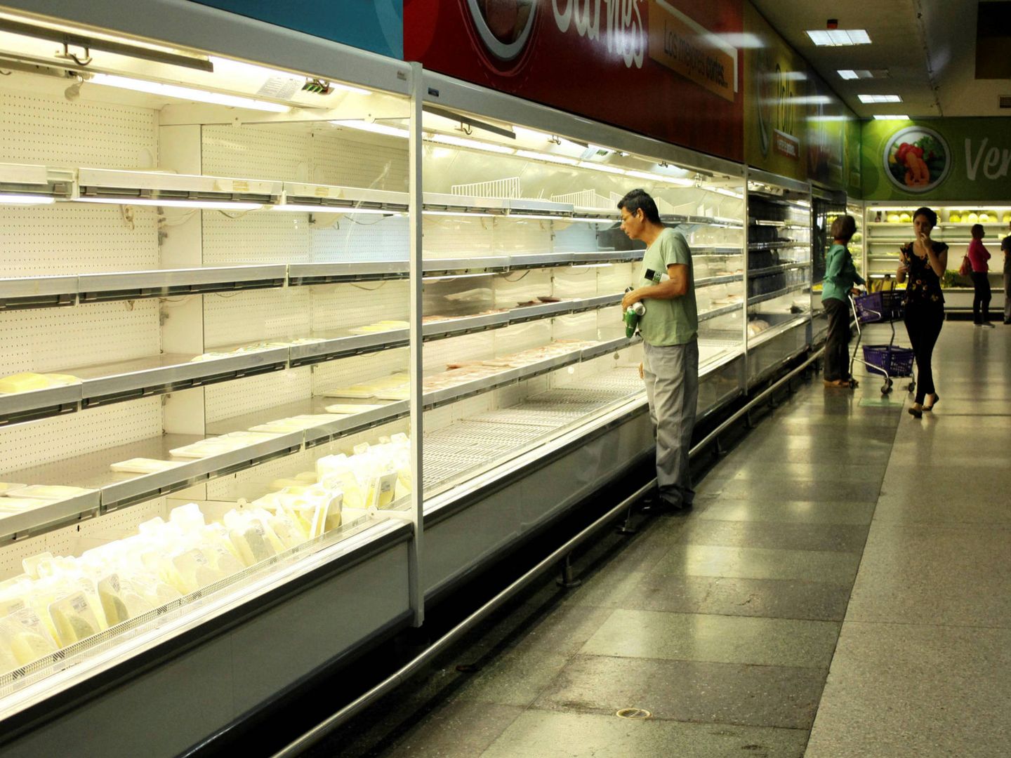 Un venezolano busca productos en un refrigerador en un supermercado en San Cristóbal, Venezuela. (Reuters)