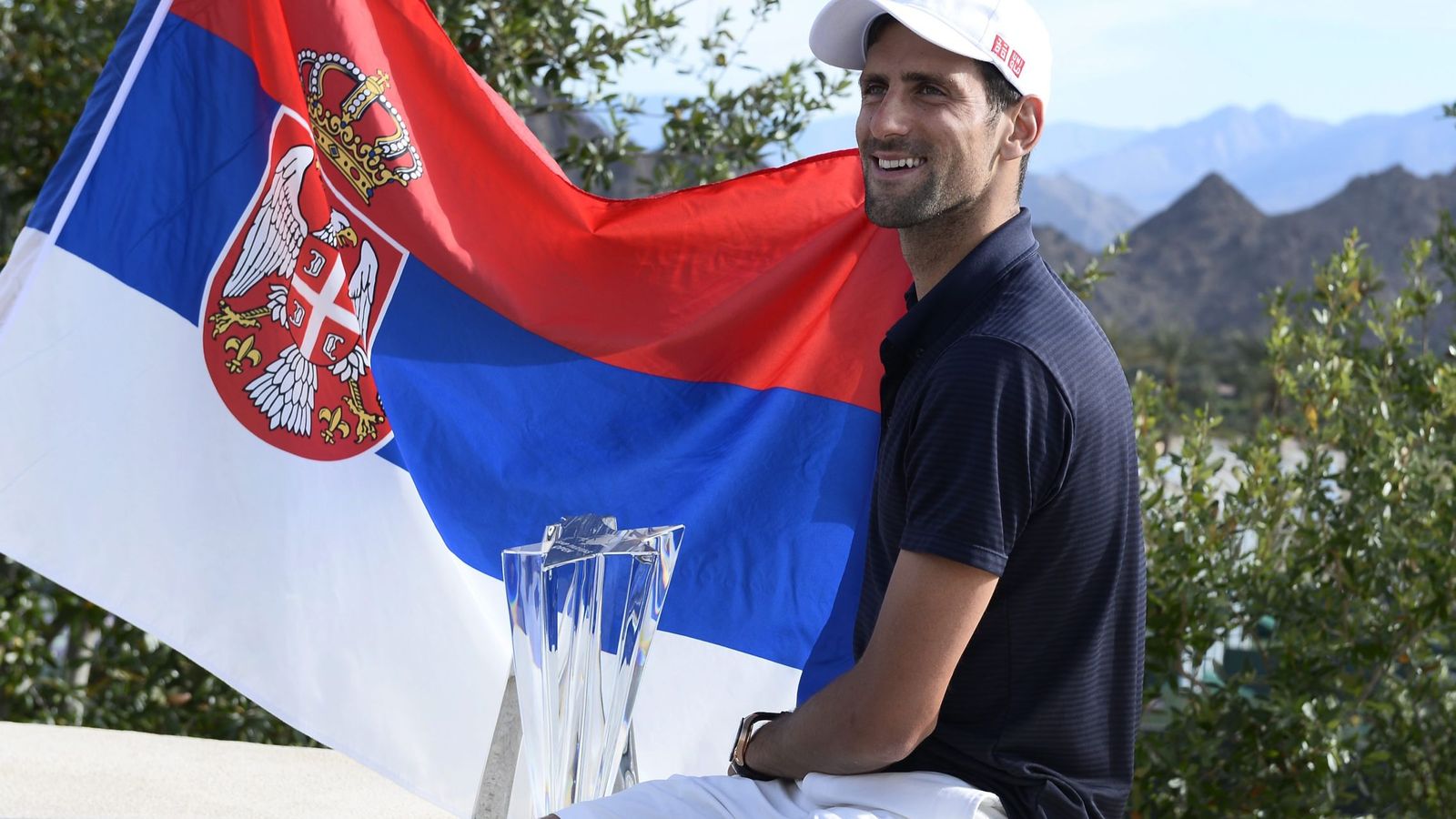 Foto: Novak Djokovic posa con la bandera serbia y el título de campeón en Indian Wells (Efe)