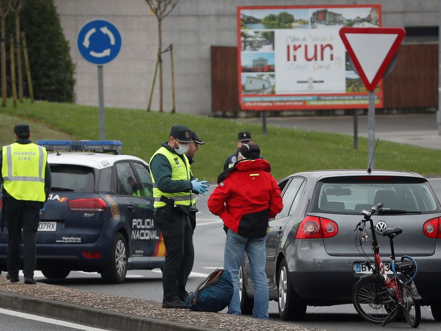 Agentes de la Guardia Civil y Policía Nacional niegan el paso a España a un ciclista en la frontera de Behobia. (EFE)