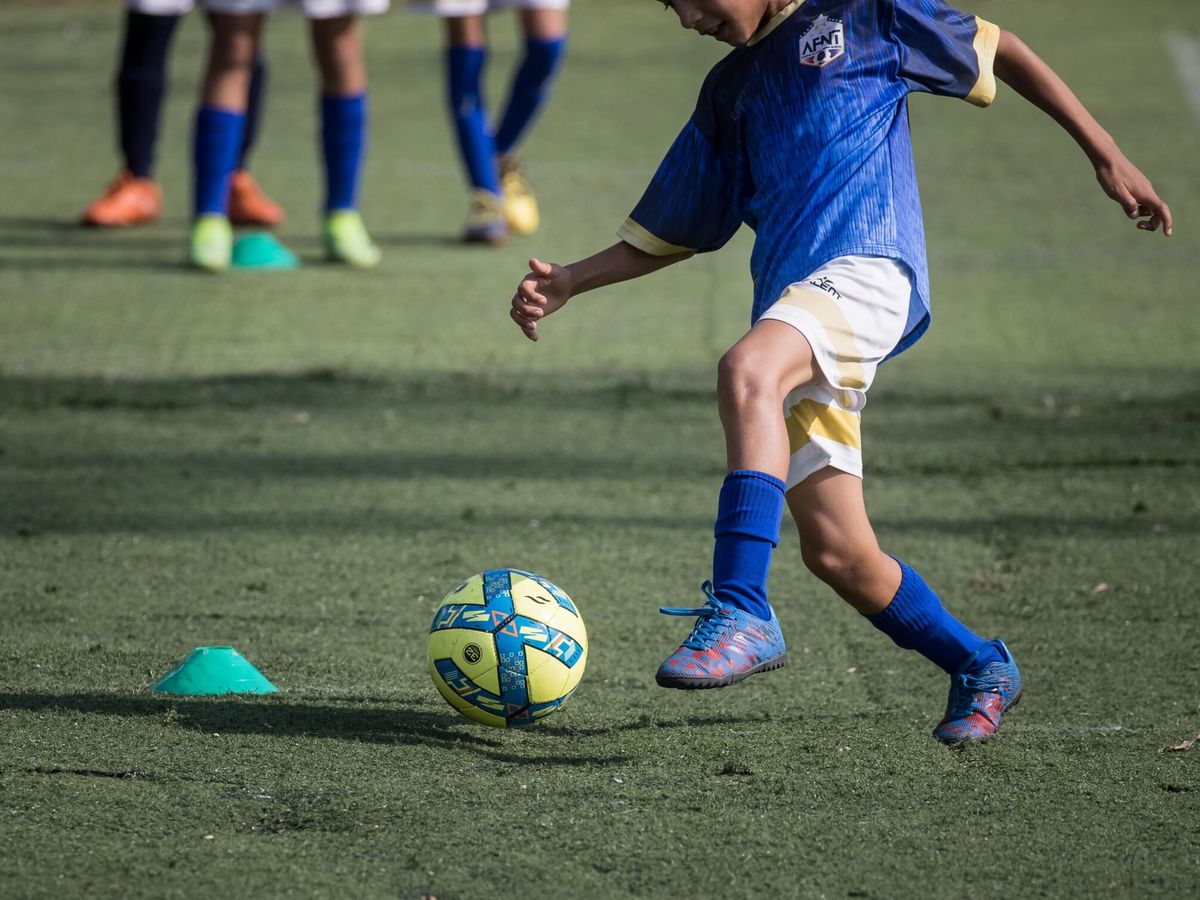 Foto: Unos niños juegan al fútbol en una academia. (EFE/Miguel Gutiérrez)
