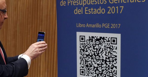 Foto: El ministro de Hacienda, Cristóbal Montoro, escanea con el móvl el código QR del proyecto de Ley de Presupuestos Generales del Estado. (EFE)