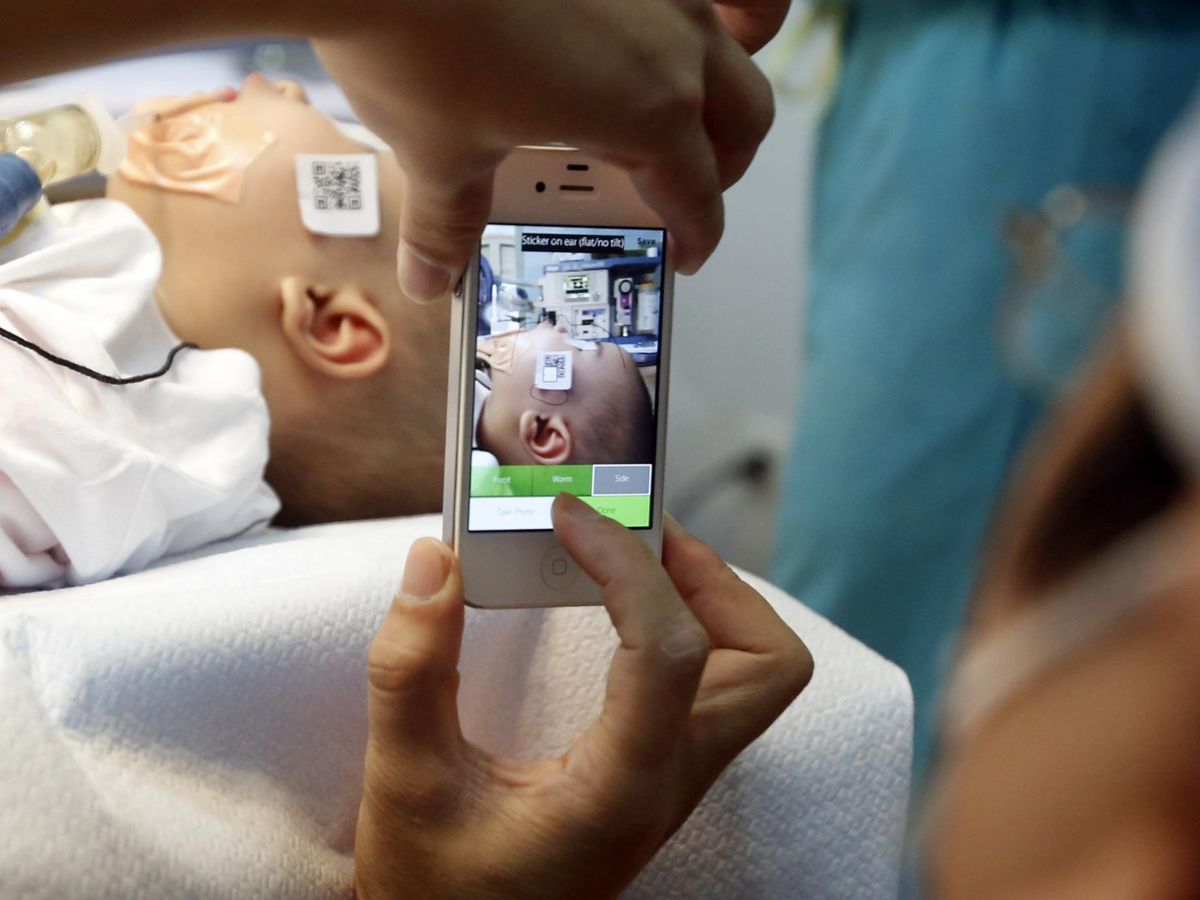 Foto: Un médico hace una foto de un bebé con deformidad facial antes de operarlo en Vietnam, 2014. (Reuters)