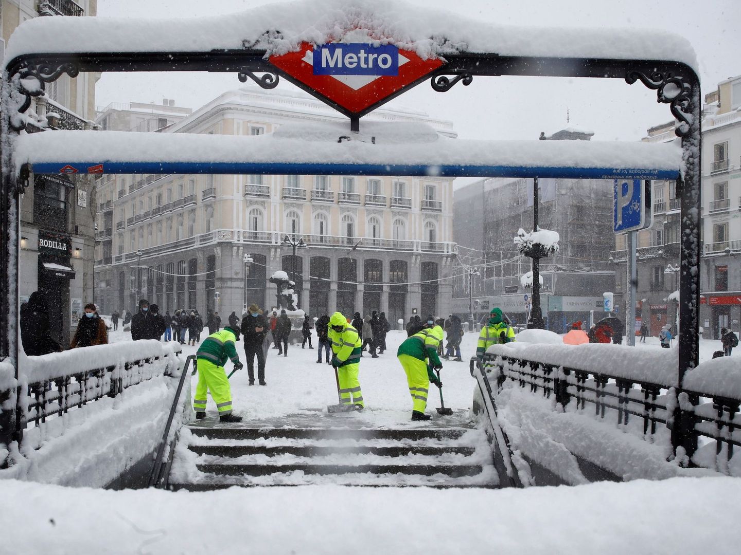 Operarios trabajan para retirar nieve y mejorar la circulación en la Puerta del Sol en Madrid, este sábado. (EFE)