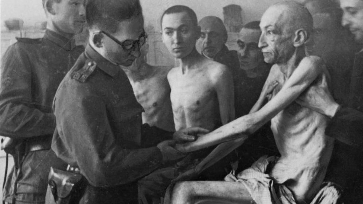 Un militar sanitario de la ‘Armada Roja’ soviética examina a uno de los supervivientes de Auschwitz tras su liberación el 27 de enero de 1945