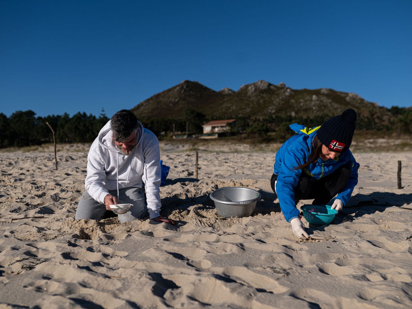 Voluntarios hacen una recogida de pellets de la arena. (Europa Press/Elena Fernández)