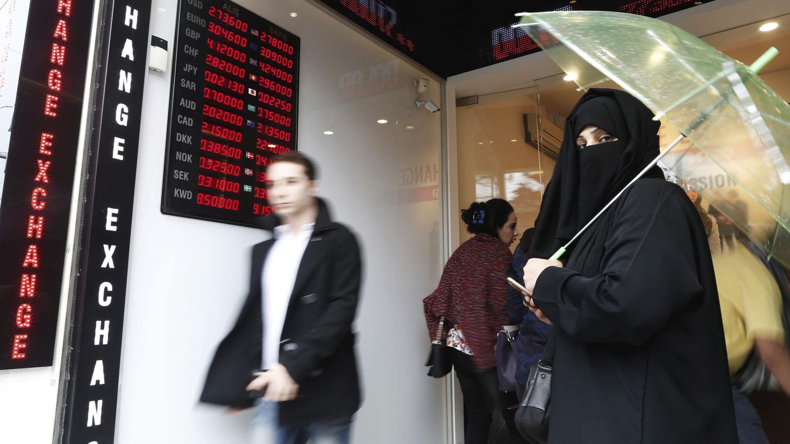 Foto: Varias personas caminan junto a una oficina de cambio de divisias en Estambul. (EFE)